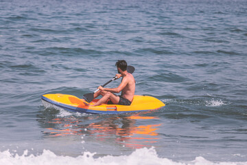 person in kayak . beach lifeguard man running for saving people from drowning in the water with high waves using kayak