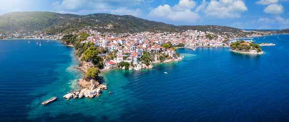 Panoramic view to the harbor and town of Skiathos island, Sporades, Greece, with Bourtzi peninsula and Plakes area in front - obrazy, fototapety, plakaty