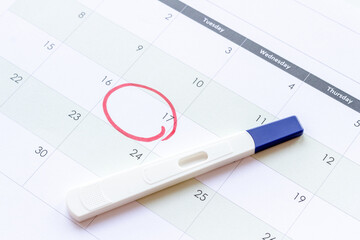 Calendar with pregnancy test, top view. Morherhood and pregnancy concept