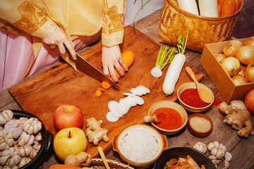 Top view Korean women use a carrot knife to make kimchi, a traditional recipe of Korean culture with fresh and quality ingredients.