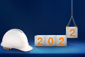 engineer working table and lifting concrete cube by crane construction for preparation of welcome...