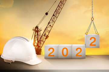 engineer working table and silhouette of a crane construction and golden sky for preparation of...