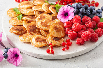 american mini pancake board with berries and maple syrup