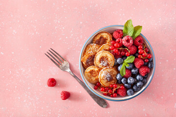 mini pancake breakfast bowl with berries and maple syrup