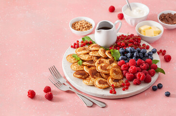 american mini pancake board with berries and maple syrup