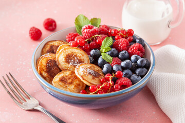 mini pancake breakfast bowl with berries and maple syrup