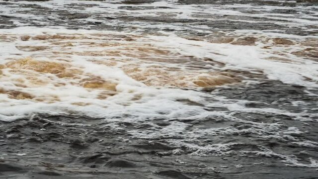 seething dirty water falling into the river. Pollution of the environment, rivers and lakes.