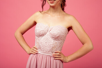 macro details of corset dress with lace on thin model, isolated on pink background.