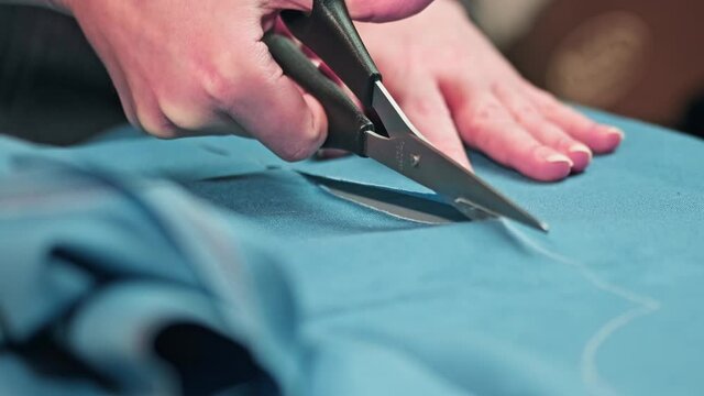 seamstress hands cut a pattern with scissors. Cutting and sewing at home. Self made.