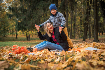 family in an autumn pack, yellow leaf fall, emotional boy and mom
