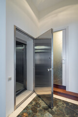 Modern interior of entrance in luxury apartment. Opened iron door.