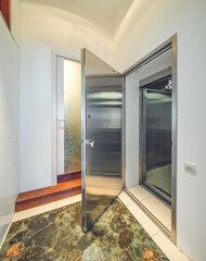 Modern interior of entrance in luxury apartment. Opened iron door.