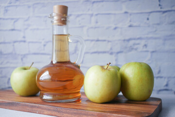 apple vinegar in glass bottle with fresh green apple on table 
