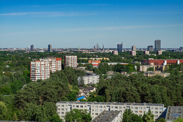 Fototapeta na wymiar Summer cityscape of Riga. Top view. Urban architecture. Green trees.