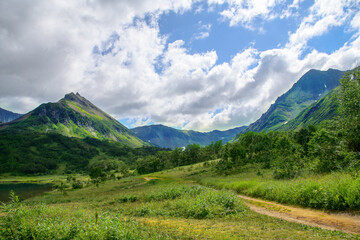 Landscape. Beautiful view of the Vachkazhets mountain range, a mountain meadow and a hiking trail that leads to the foot of an ancient volcano. Kamchatka Peninsula