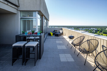 Sunbeds on outdoor terrace in luxury apartment. Table and chairs