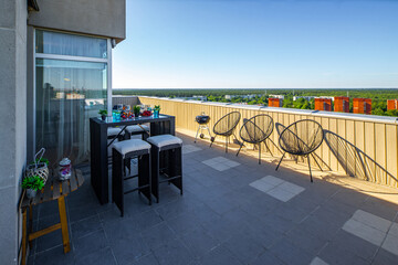 Spacious outdoor terrace in luxury apartment. Table and chairs