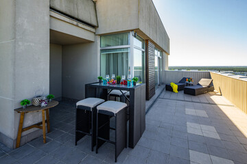 Sunbeds on outdoor terrace in luxury apartment. Table and chairs