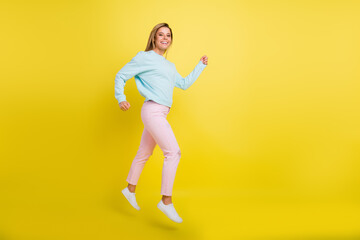Fototapeta na wymiar Full length body size profile side view of attractive cheerful girl jumping going isolated over bright yellow color background
