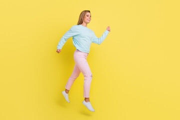 Fototapeta na wymiar Full length body size view of attractive cheerful girl jumping walking wearing cozy clothes isolated over bright yellow color background