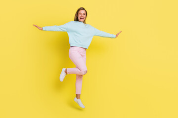 Fototapeta na wymiar Full length body size view of attractive cheerful carefree girl jumping having fun isolated over bright yellow color background