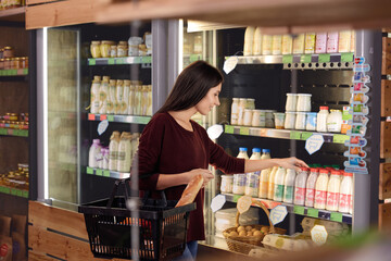 Woman choosing milk product in food store