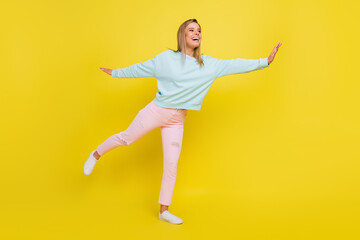 Fototapeta na wymiar Full length body size view of attractive glad cheerful girl flying having fun isolated over bright yellow color background