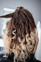 stylist hairdresser makes a hairstyle for a girl in his beauty salon, hollywood wave, beautiful hairstyle, hairdresser at work