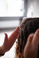 Fototapeta premium stylist hairdresser makes a hairstyle for a girl in his beauty salon, hollywood wave, beautiful hairstyle, hairdresser at work