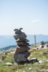 Closeup of stone balance at the top of the mountain on blue sky background