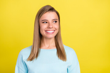 Portrait of attractive cheerful girl wearing blue sweater thinking looking aside copy space isolated over bright yellow color background