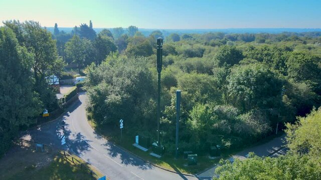 Wide drone shot circling around 5G telecoms mast.
