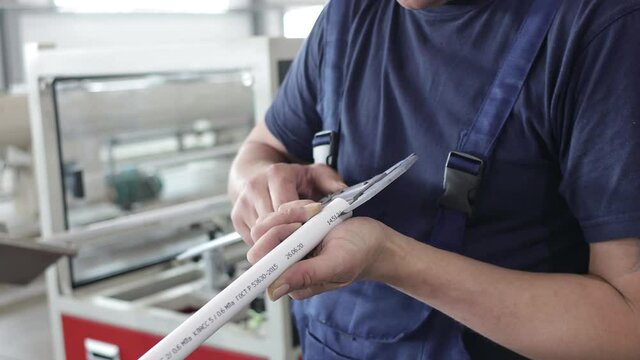 factory worker engineer checks the quality of polypropylene pipes