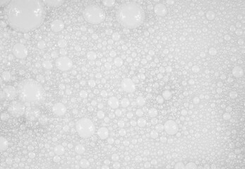 Texture of small soap bubbles on water background. foam