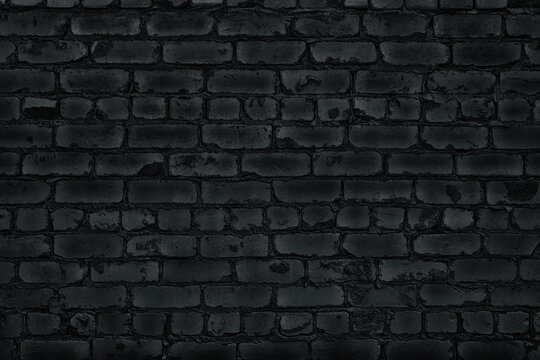 Black old rough shabby brick wall texture. Abstract gloomy grunge background