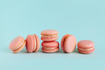 Tasty french pink macarons on a blue pastel background.