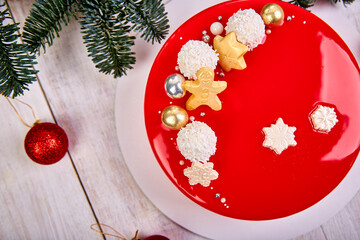 Mousse Christmas pastry cake dessert covered with red mirror glaze with new year decorations on...