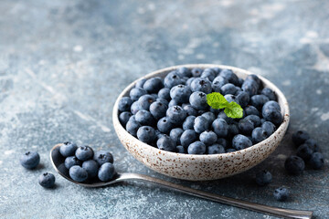 Obraz na płótnie Canvas Organic blueberries in bowl. Healthy summer berries rich in vitamins and antioxidants