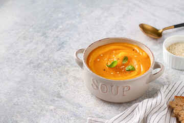 Orange puree soup in a tureen, empty seat