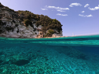 Underwater sea level split photo of beautiful paradise turquoise exotic beach of Voutoumi probably the best in Greece, Ionian island of Antipaxos