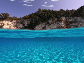 Fototapeta premium Underwater sea level split photo of beautiful paradise turquoise exotic island beach in Caribbean island destination