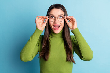 Photo of crazy shocked funny lady hands hold specs open mouth wear green turtleneck isolated on blue background