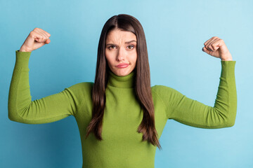 Photo of doubtful uncertain lady raise muscular hands grimace wear green turtleneck isolated on...
