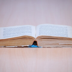 An open book on a wooden table. Selective focus