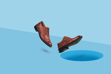 Men's  brown leather shoes in motion falling into dark hole in a floor.