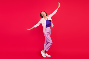 Photo of positive glad lady beaming smile fly hands wings wear pink jacket isolated red color background