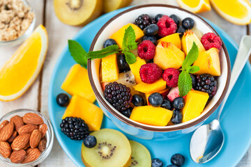 Concept of low calories delicious desserts. Summer fresh bowl with colorful fruit salad. Healthy...