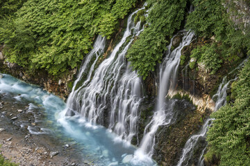 waterfall in the forest with blue liver in Hokkaido Japan