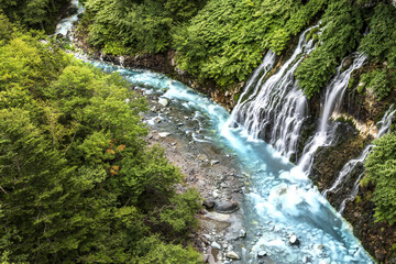 waterfall in the forest with blue liver in Hokkaido Japan