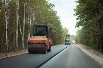 Road roller thickening just made new asphalt lane. Road construction in the countryside
